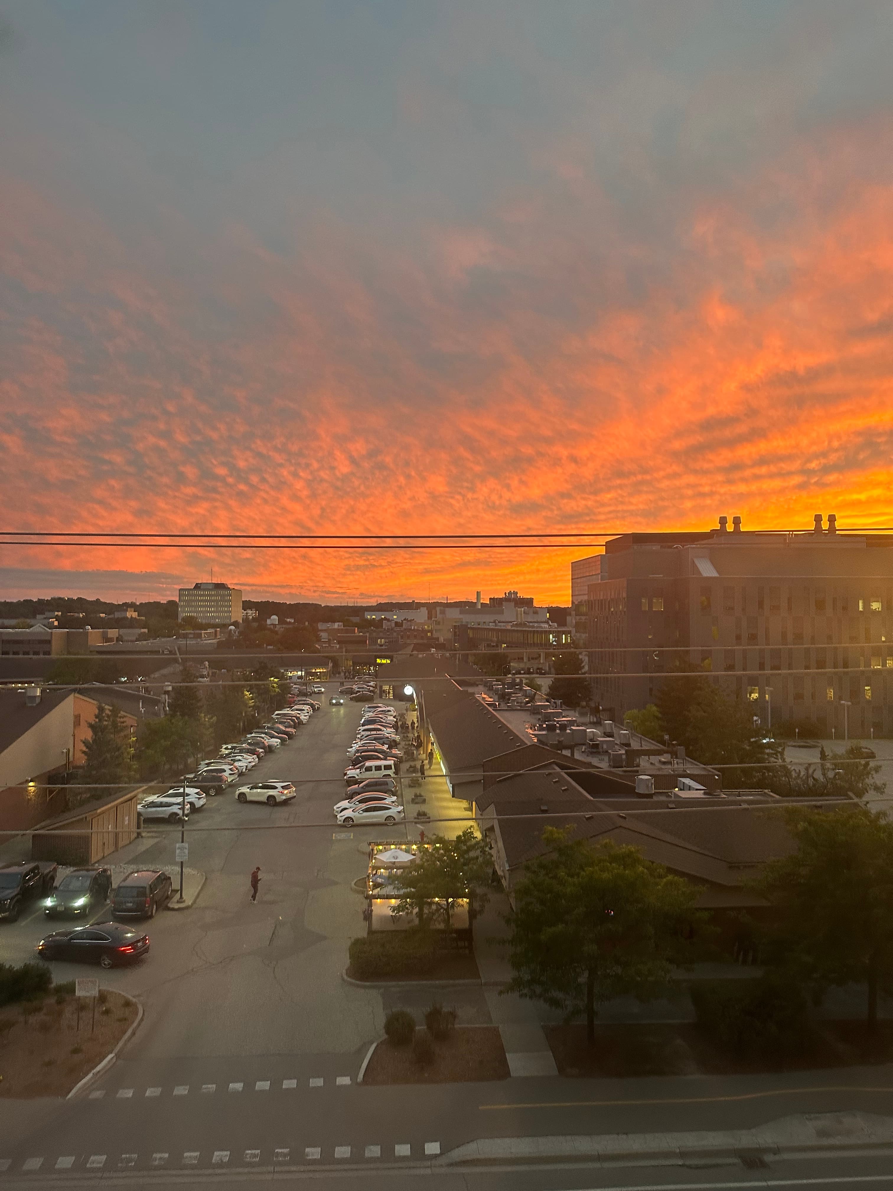 An orange sunset over campus, seen from an upper floor.